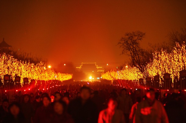 Visitors look at the laser performance in front of the Yongdingmen Gate